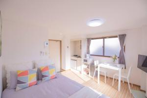 a bedroom with a bed and a desk and a kitchen at 閑静な住宅街_暖かく居心地の良いデザイン SoW-2 in Tokyo