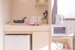 a kitchen with a white microwave and a sink at 閑静な住宅街_暖かく居心地の良いデザイン SoW-2 in Tokyo