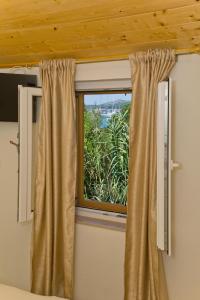 a window with curtains in a room with a view at Robinson house T'n'T in Hvar