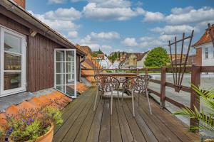 a wooden deck with a table and chairs on it at fewo1846 - Kaete-Lassen-Huus - uriges Häuschen auf 3 Ebenen mit Dachterrasse am Hafen in Flensburg