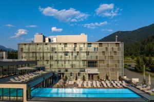 a hotel with a swimming pool and a resort at Arena Franz Ferdinand Nassfeld in Tröpolach