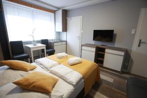 a hotel room with two beds and a television at Pod Różami in Grzybowo