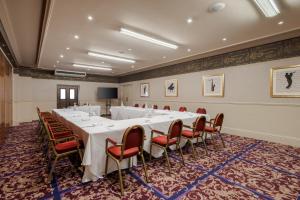 una sala conferenze con un lungo tavolo e sedie di Reigate Manor Hotel a Reigate