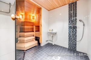 y baño con ducha y lavamanos. en Holiday Apartments Suomun Lumous en Suomutunturi