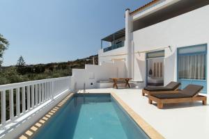 a villa with a swimming pool and a house at Andros Moments Suites in Batsi