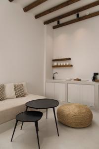 a living room with a bed and a table and a kitchen at Andros Moments Suites in Batsi