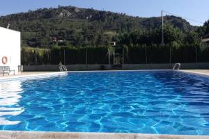 AndillaにあるCasa rural La Murallaの山を背景にした青い大型スイミングプール