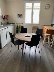 cocina y comedor con mesa y sillas en Appartement dans maison d'artiste en Lunel