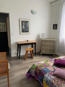 um quarto com uma cama e uma mesa de madeira em Appartement dans maison d'artiste em Lunel