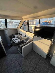 a view of a room with a table and a tv at YACHT "X" - 44 FOOT MODERN YACHT ON 5 STAR OCEAN VILLAGE MARINA - minutes away from city centre and cruise terminals, Free parking ,SPA package available! in Southampton