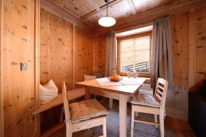 a wooden dining room with a table and chairs at Ferienwohnungen Peisserhof in Sillian