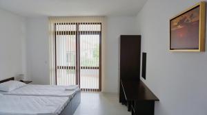 a bedroom with two beds and a large window at вила Ема Балчик - villa Ema Balchik in Balchik