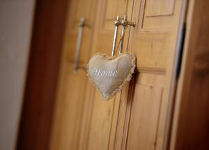 a heart hanging on a door with the words home at Ferienwohnungen Peisserhof in Sillian