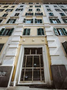 un alto edificio bianco con porta e finestre di Casa Fabrizio - Metro San Giovanni a Roma