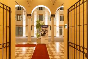 Cà Uberti Palace Hotel في مانتوفا: باب مفتوح لمبنى فيه لافته في الممر