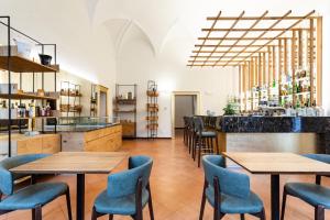 um restaurante com mesas de madeira e cadeiras azuis em Cà Uberti Palace Hotel em Mantova