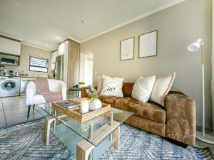 uma sala de estar com um sofá e uma mesa em Garden Unit Inverter,nespresso,blender,netflix em Joanesburgo