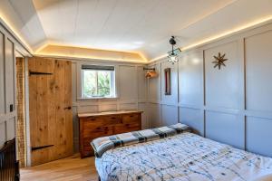 1 dormitorio con 1 cama, vestidor y ventana en Finest Retreats - Driftwood, en Poundstock