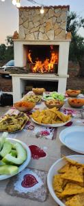 a table with plates of food and a fireplace at TRULLO CARMEN in San Michele Salentino