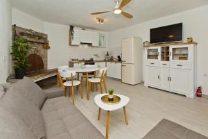 a living room with a couch and a table and a kitchen at Robinson house T'n'T in Hvar