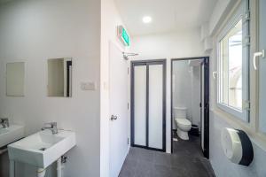 a white bathroom with a sink and a toilet at K Space Inn 14 in Singapore
