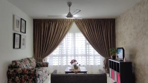 a living room with a couch and a large window at Al Fateh Homestay Apartment in Putrajaya in Putrajaya