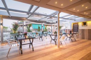 a patio with tables and chairs on a wooden floor at Lume Athens in Athens