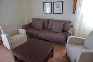 een woonkamer met een bank en 2 stoelen bij Jardines de La Santa in Totana