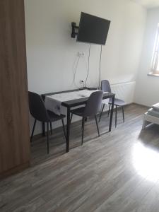 a dining room table with two chairs and a tv at Staś -przy szkole nr 3 w Skawie in Skawa