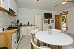 a kitchen with a white table and a white table and chairs at Robinson house T'n'T in Hvar