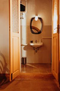 W łazience znajduje się umywalka i lustro. w obiekcie Dolce Vita Assedio w mieście Pitigliano