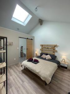 a bedroom with a large bed and a skylight at Les Iris - Chambre Chêne in Avanton