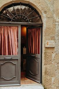 wejście do budynku z drzwiami i oknem w obiekcie Dolce Vita Assedio w mieście Pitigliano
