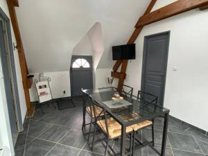 a dining room with a glass table and chairs at Appart à la ferme, chez Shoopie 