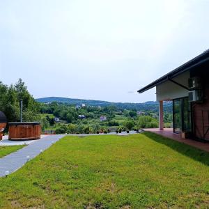 un gran campo de césped junto a un edificio en ArPioNa dom nad jeziorem z jacuzzi, sauną i placem zabaw, en Dąbrówka