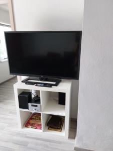 a flat screen tv on a white entertainment center at Schöne Wohnung direkt am Bach in Neunkirchen am Sand