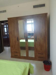 a wooden cabinet with glass doors in a room at golden land in Sharjah