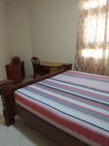 a bed in a room with a chair and a window at golden land in Sharjah