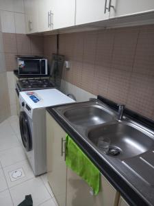 a kitchen with a sink and a washing machine at golden land in Sharjah