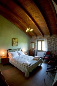a bedroom with a large bed and a stone wall at Farma Sarli in Monódhrion