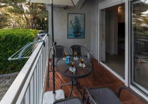 eine Terrasse mit einem Tisch und Stühlen auf dem Balkon in der Unterkunft Apartment Anamaria with Seaview in Petrcane