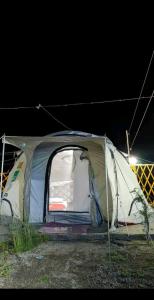 a tent sitting in a field at night at Baseet Camping and Restaurant in Gulmit