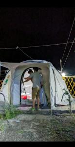 mężczyzna stojący w namiocie w nocy w obiekcie Baseet Camping and Restaurant w mieście Gulmit