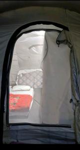 an open tent with a bed in the back of it at Baseet Camping and Restaurant in Gulmit