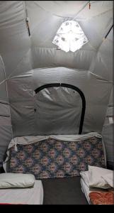 a tent with two beds and a light in it at Baseet Camping and Restaurant in Gulmit