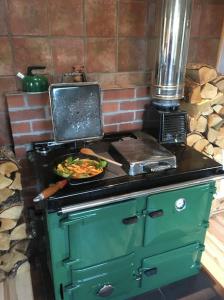 a green stove with a plate of food on it at The Neuk Achmore Plockton in Stromeferry
