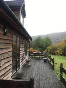 una terraza de madera junto a una cabaña con mesa de picnic en The Neuk Achmore Plockton en Stromeferry