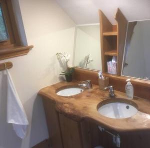 uma casa de banho com 2 lavatórios e um espelho em The Neuk Achmore Plockton em Stromeferry