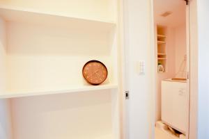 une horloge assise sur une étagère dans une pièce dans l'établissement 10min walk to Shinjuku YEoE-2, à Tokyo