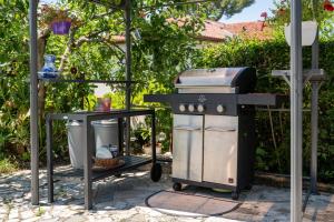 a grill and a trash can in a garden at Apartments Villa Bazilika in Sečovlje